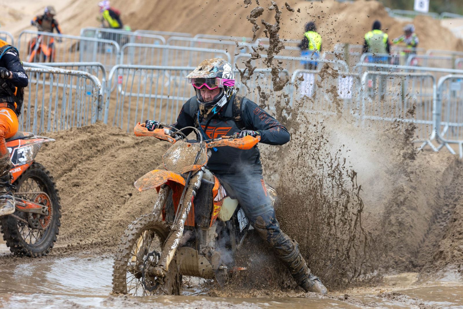A motorbike and rider splash through a muddy puddle at the Weston-super-Mare Beach Race